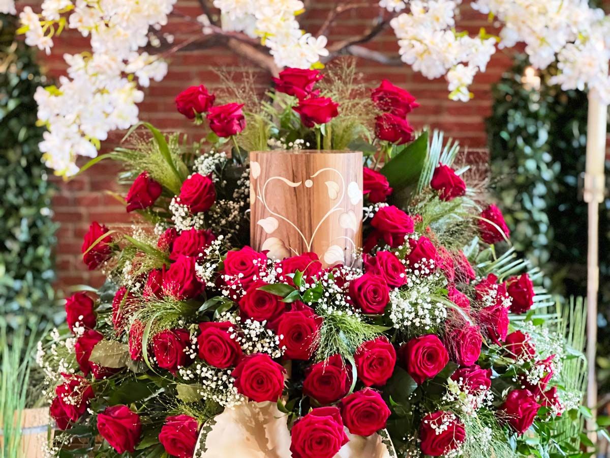 Zylinderförmige Holzurne mit Blumengesteck, rote Rosen